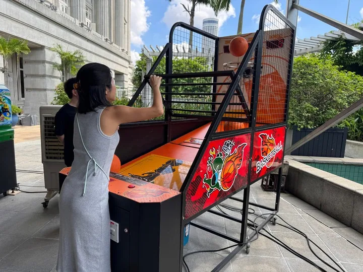 A guest playing arcade basketball at a BounceParkSG setup