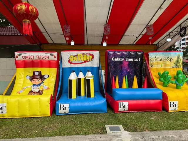 Inflatable game booths lined up under a canopy by BounceParkSG
