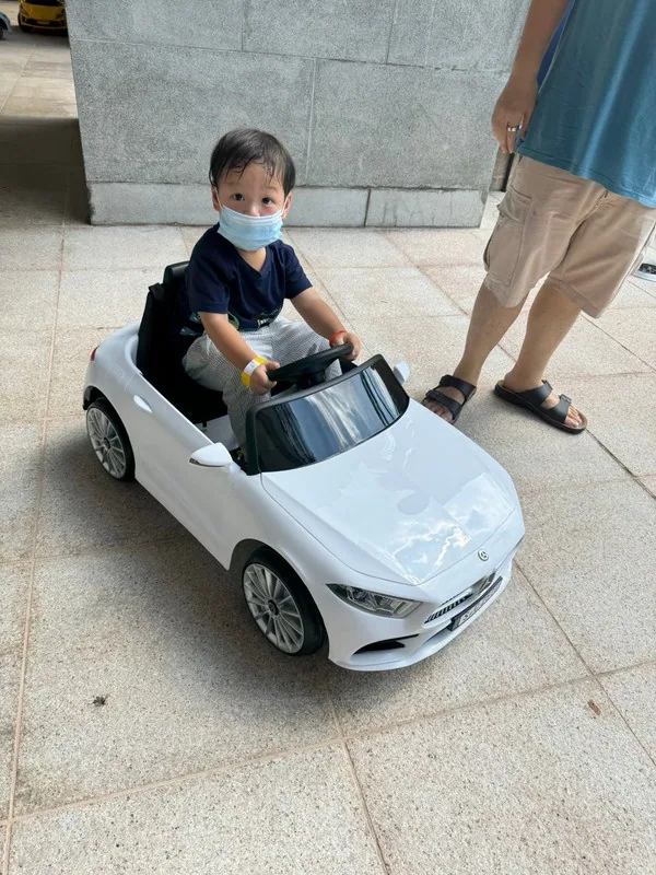 A child driving a toy car ride