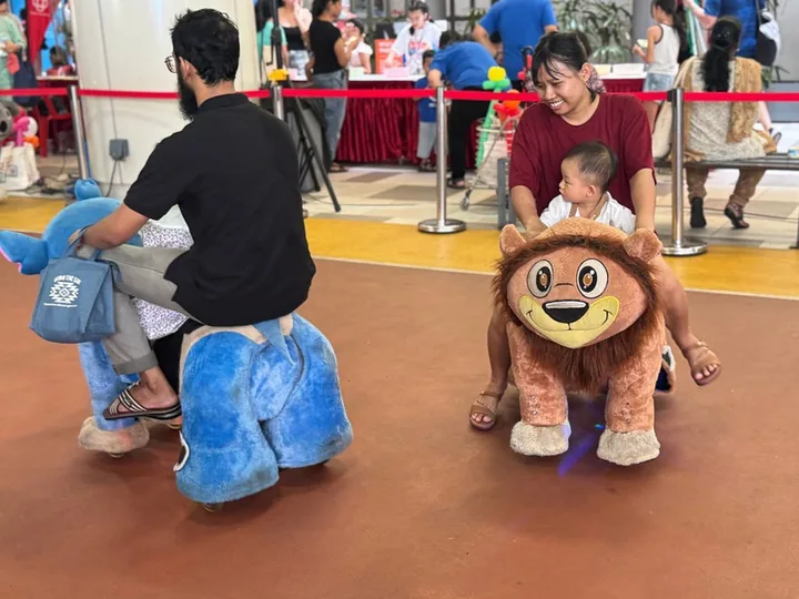 A toddler riding an electronic animal ride by BounceParkSG